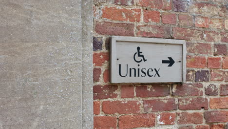 unisex disables toilets restroom sign on a brick wall