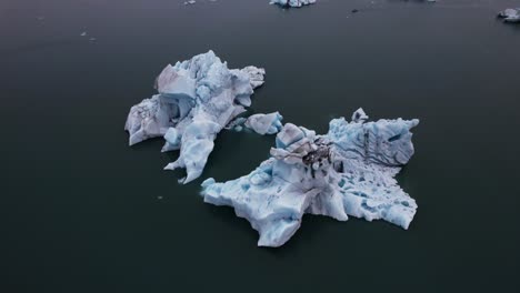 dynamic descent around a massive iceberg in iceland - gloomy day