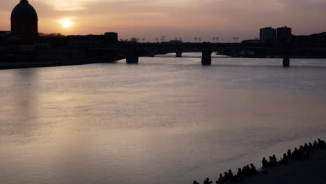 The-Saint-Pierre-Bridge-in-Toulouse,-France-at-sunset-with-the-skyline,-bridge-and-people-in-silhouette