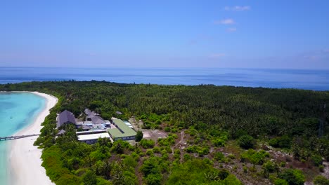 Ein-Blick-Auf-Ein-Resorthotel-Und-Seine-Holzterrasse-Auf-Dem-Türkisfarbenen-Meer-Auf-Den-Malediven,-Drohnenaufnahmen-Vom-Senkrechten-Meer-Heben-Ab