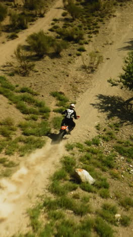 motociclista monta vehículo a lo largo de la carretera de tierra fpv dron. deportista extremo en motocicleta disfruta de un viaje a través del valle montañoso. competencia de carreras offroad