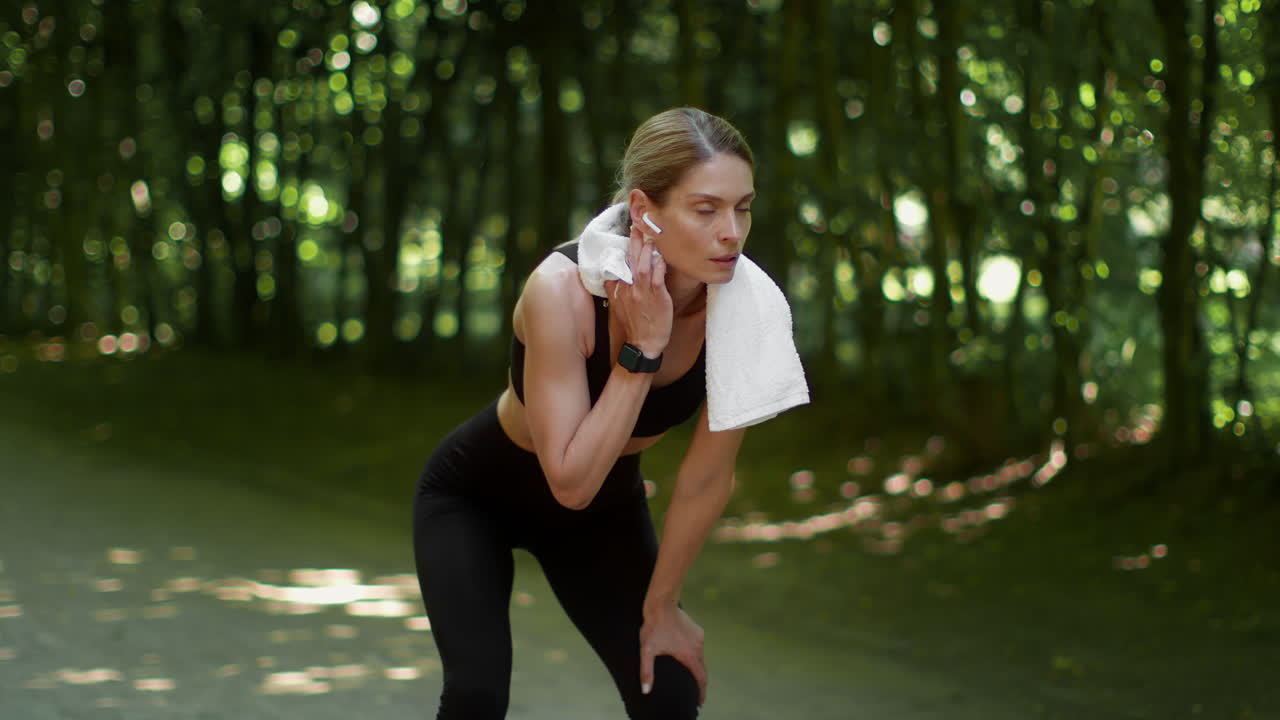 Female athlete taking a break during outdoor workout in a park