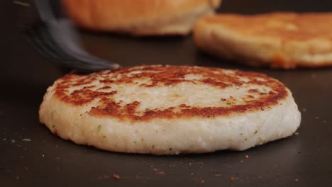 Cooking American fat smash burger on grill close-up. Chiken or fish cutlet smashing by burger press. The chef in kitchen of the restaurant making cutlets for burgers - smash burger beefsteak. Fast and street food concept. High quality 4k footage
