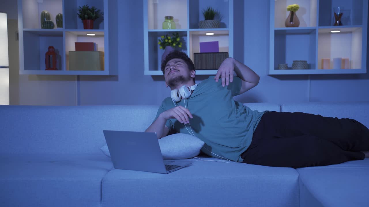 el hombre se cansa mientras usa la computadora por la noche.