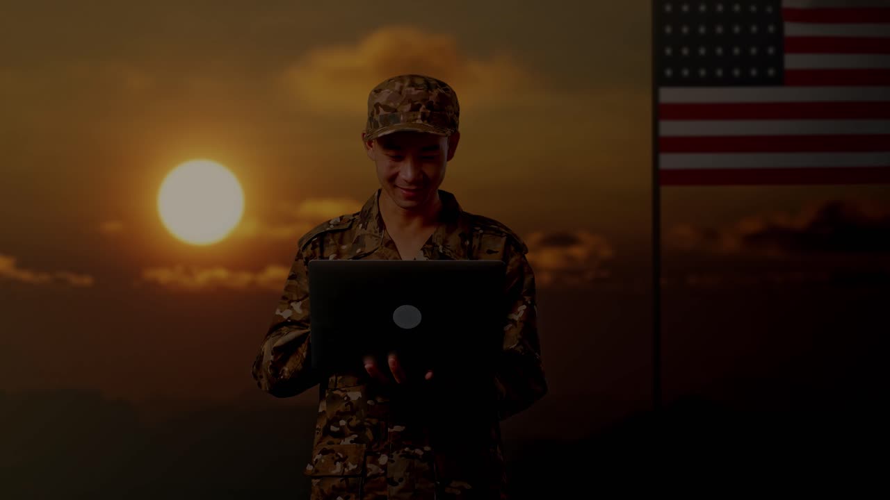 soldado usando una computadora portátil al atardecer