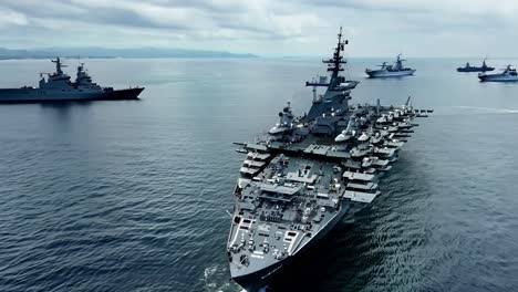 a large aircraft carrier sails in the ocean