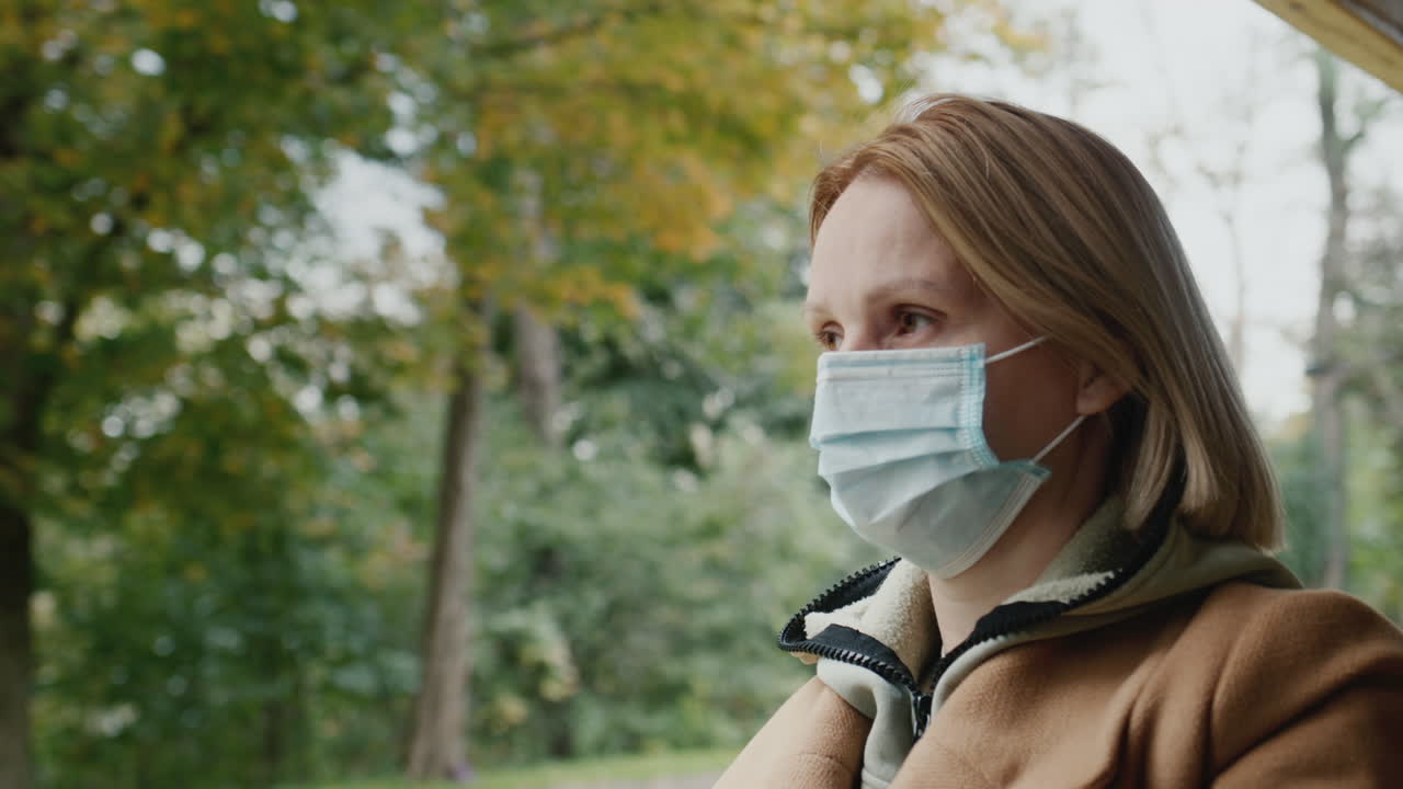 의료 마스크 를 착용 한 승객 이 열려 있는 창 근처 에 있는 트램 을 타고 있다