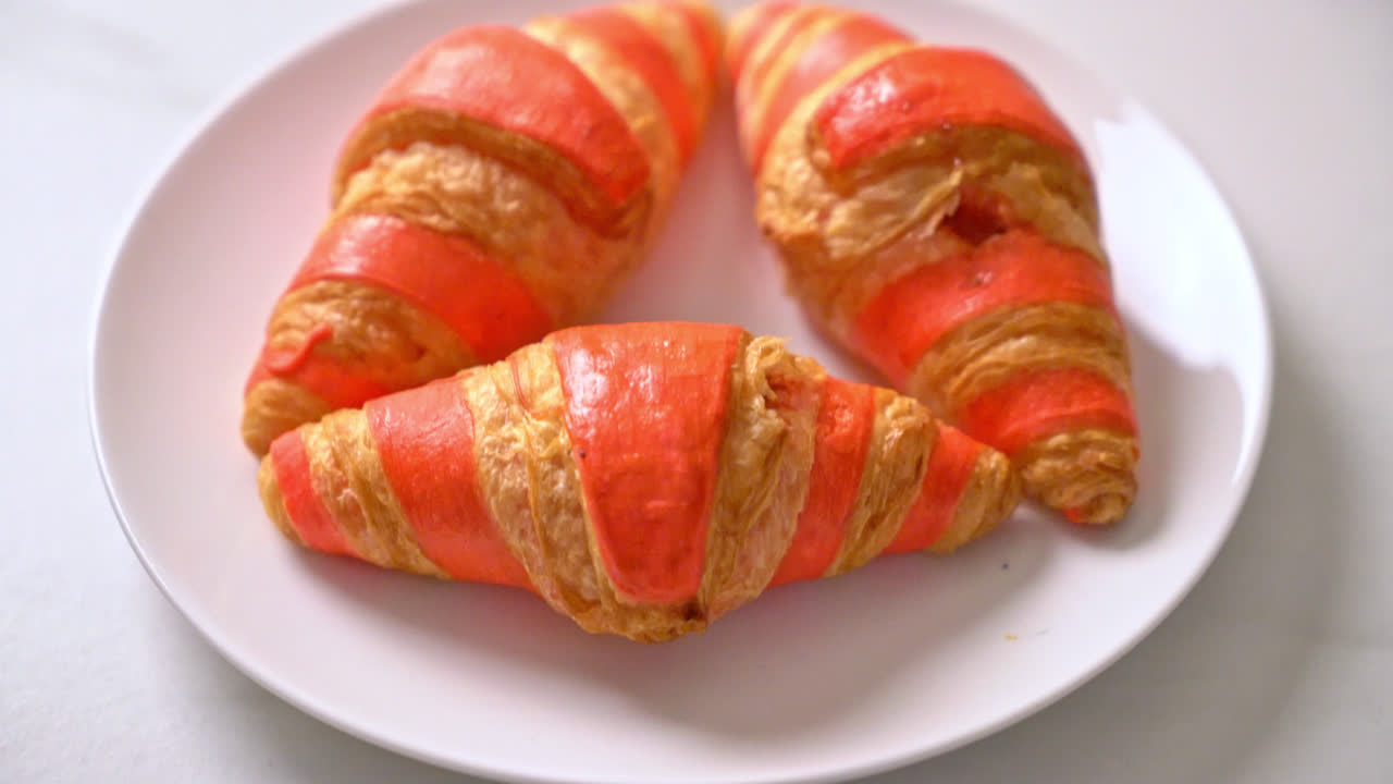 Croissant fresco con salsa de mermelada de fresa en la placa