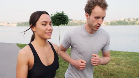 happy couple running together in the city near a river