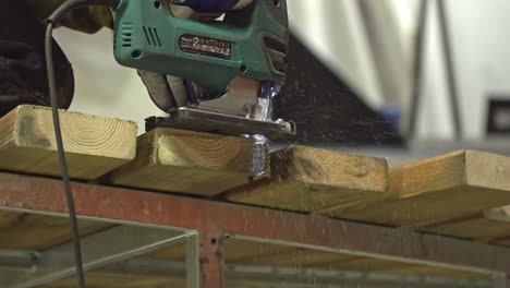 carpintero cortando algunas tablas de madera con una sierra eléctrica