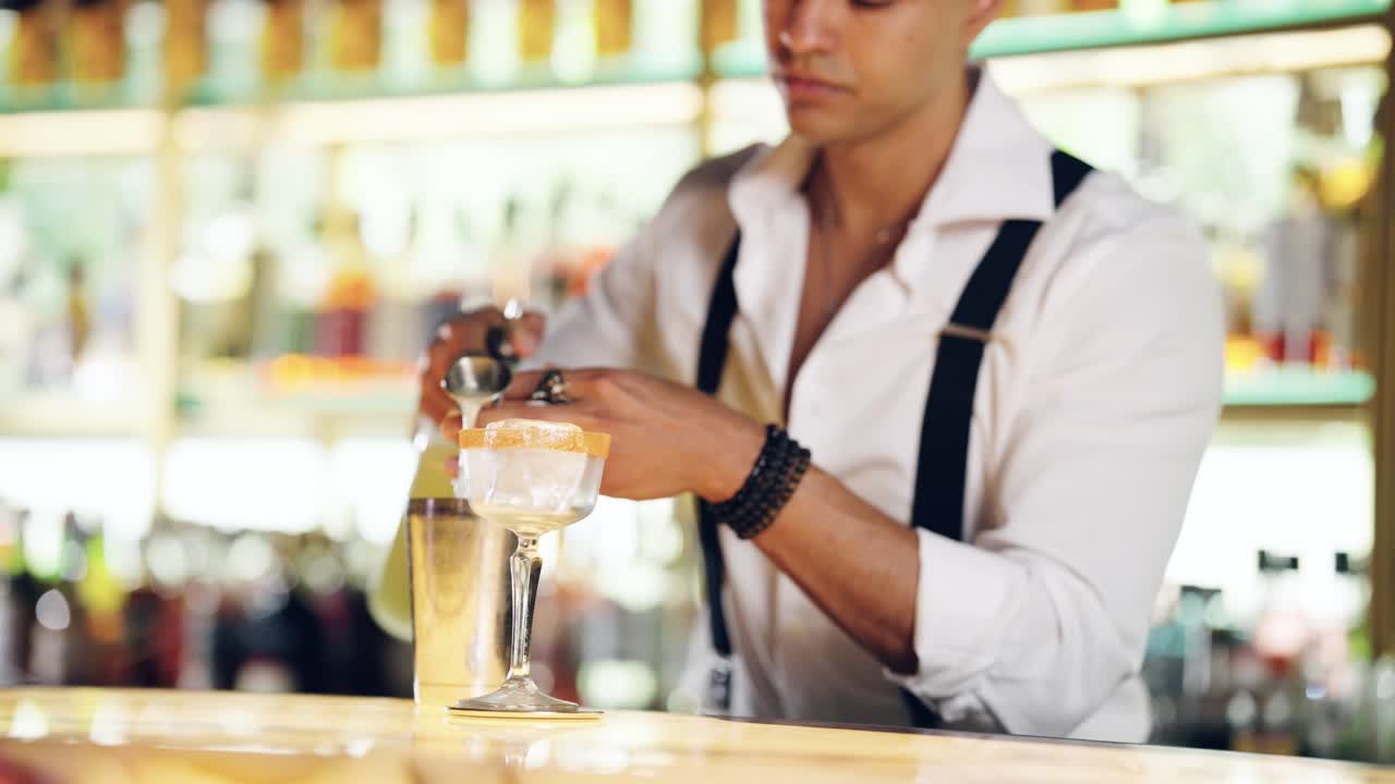 Professioneller Barkeeper gießt einen Cocktail in ein Glas an einer Bar