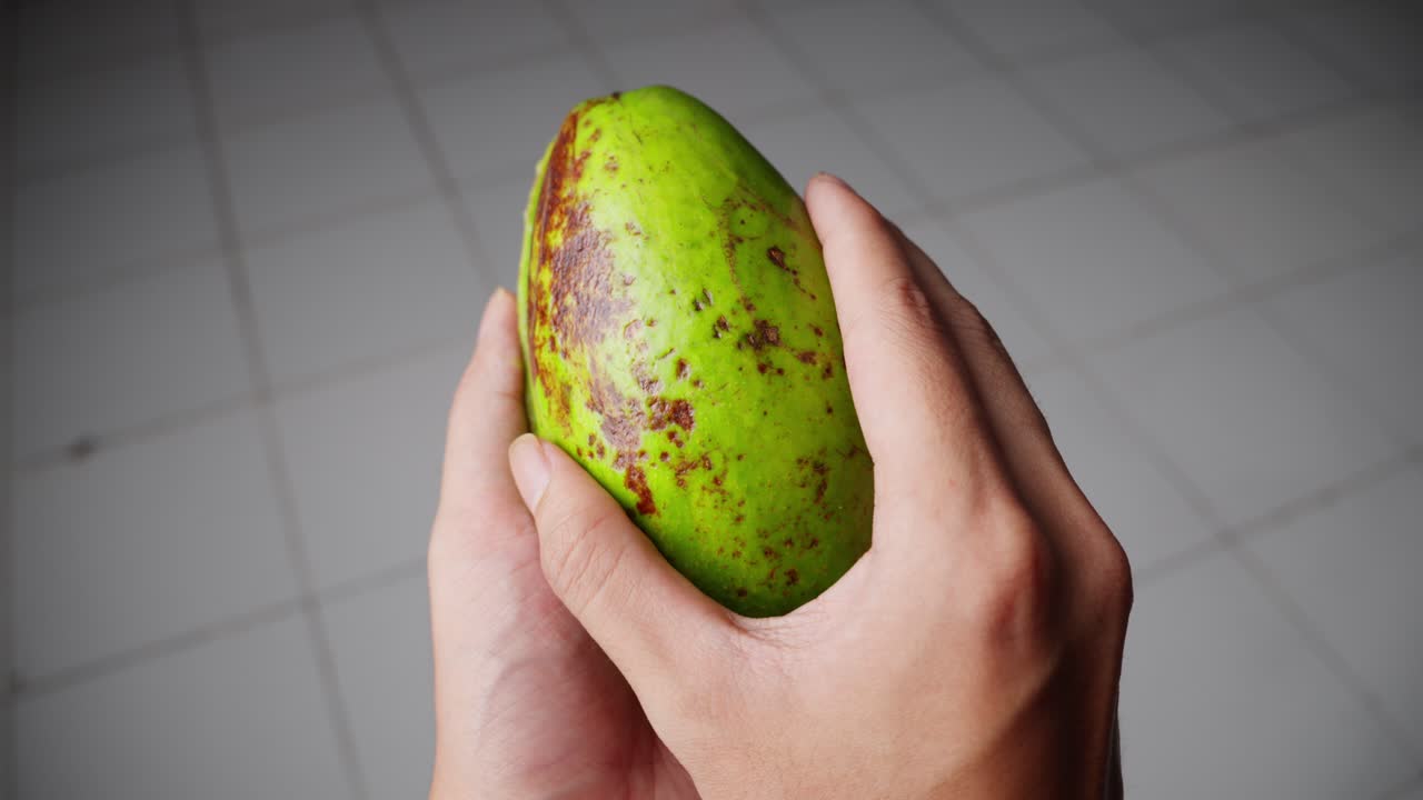 persona abriendo un aguacate a la mitad a mano