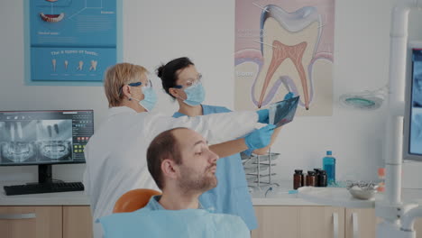 senior dentist and nurse analyzing x ray scan to find diagnosis