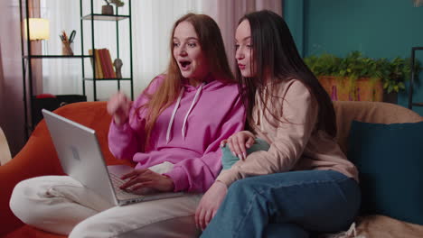 girls friends siblings celebrate success win scream rejoices, doing online shopping on laptop pc