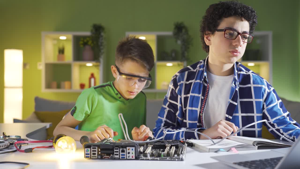Two kids trying to fix the electronic board.