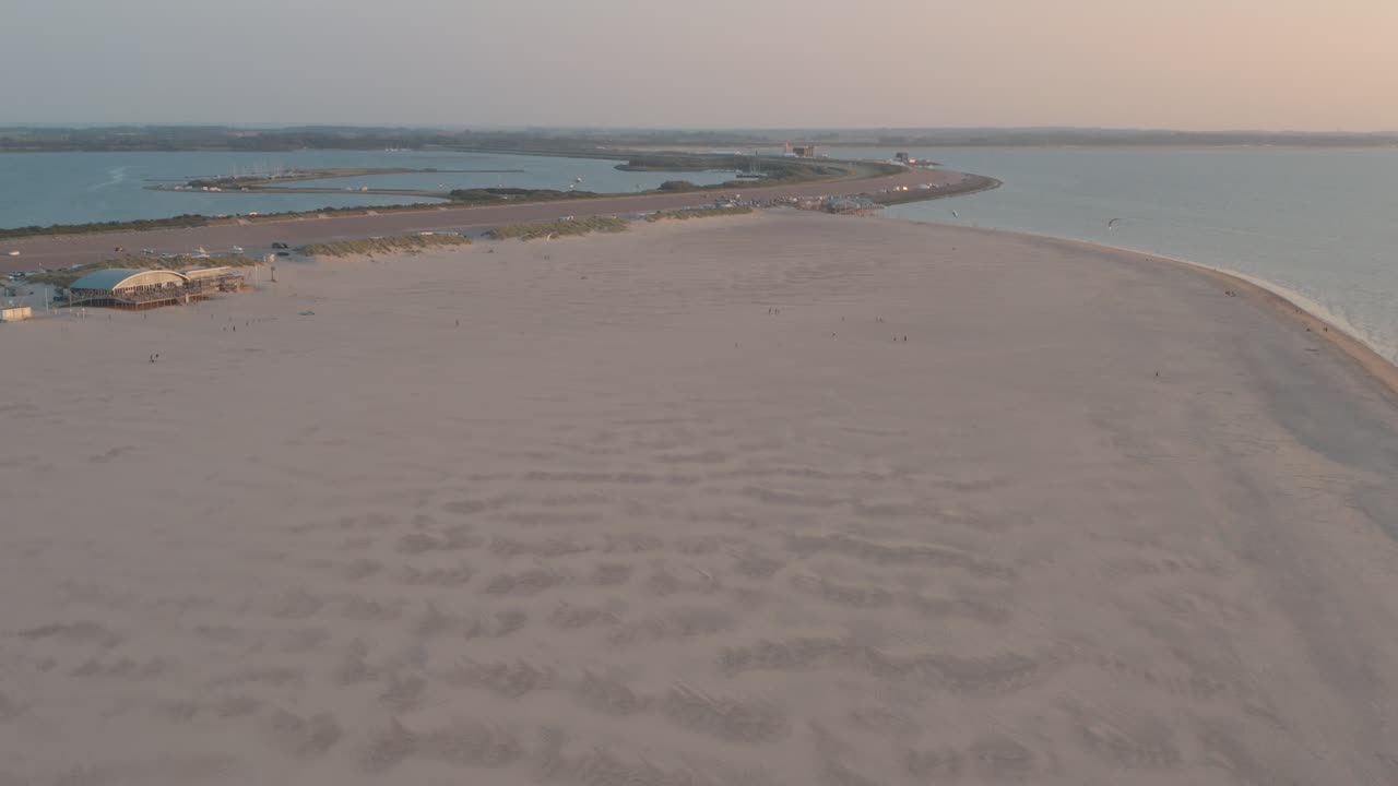 시네마틱 드론 - 25p 네덜란드 북해의 zeeland에서 버기키팅을 하는 관광객과 사람들과 함께 해질녘에 녹색과 모래가 있는 자연 해변의 공중 촬영