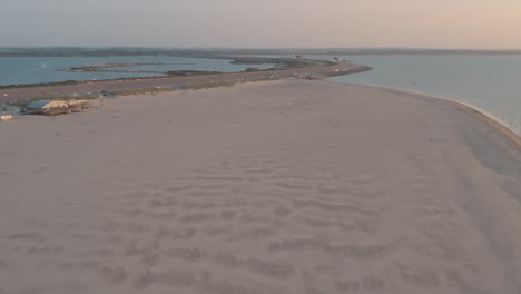 Cinematic-drone---aerial-shot-of-the-green-and-sandy-nature-beach-at-sunset-with-tourists-and-people-with-Buggykiting-at-Zeeland-at-the-north-sea,-Netherlands,-25p