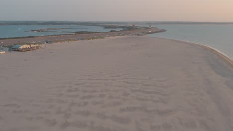 drone cinemático - toma aérea de la playa natural verde y arenosa al atardecer con turistas y personas con buggykiting en zelanda en el mar del norte, países bajos, 25p