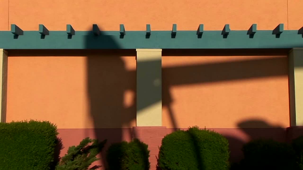 거대한 석유 굴착 장치가 칠해진 건물의 측면에 그림자를 드리웁니다.