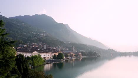 Vista-De-Drones-Del-Lago-Iseo-Al-Amanecer,-A-La-Izquierda-La-Ciudad-De-Lovere-Que-Corre-A-Lo-Largo-Del-Lago,-Bergamo-Italia