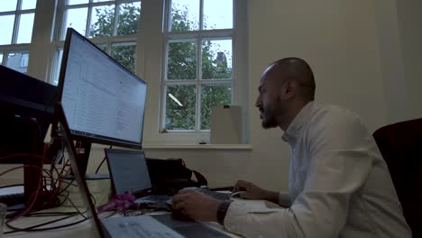young asian indian man busy work multiple screen computer or smart tablet on table desk at home in freelance data analyst, data science scientist for business