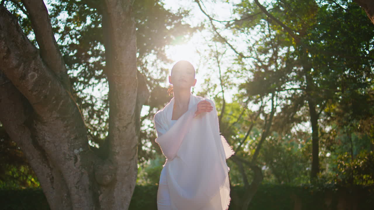 색 옷을 입고 빛을 포즈하는 실루 여성. 은 공원에서 서 있는 모델