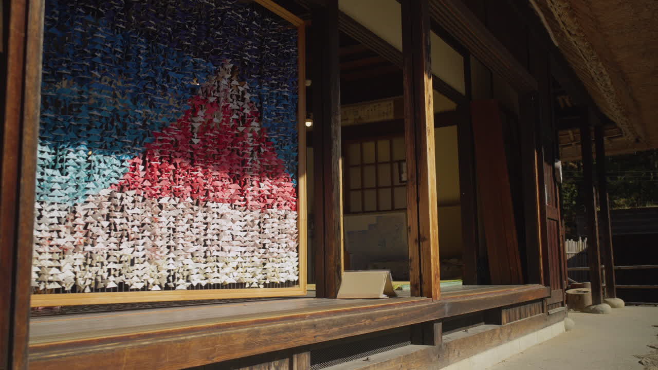 Young man walks towards traditional Japanese house with Origami art of Mt. Fuji and sits down