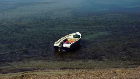 boat parked on shore of sea with calm water near mediterranean fishermen's village