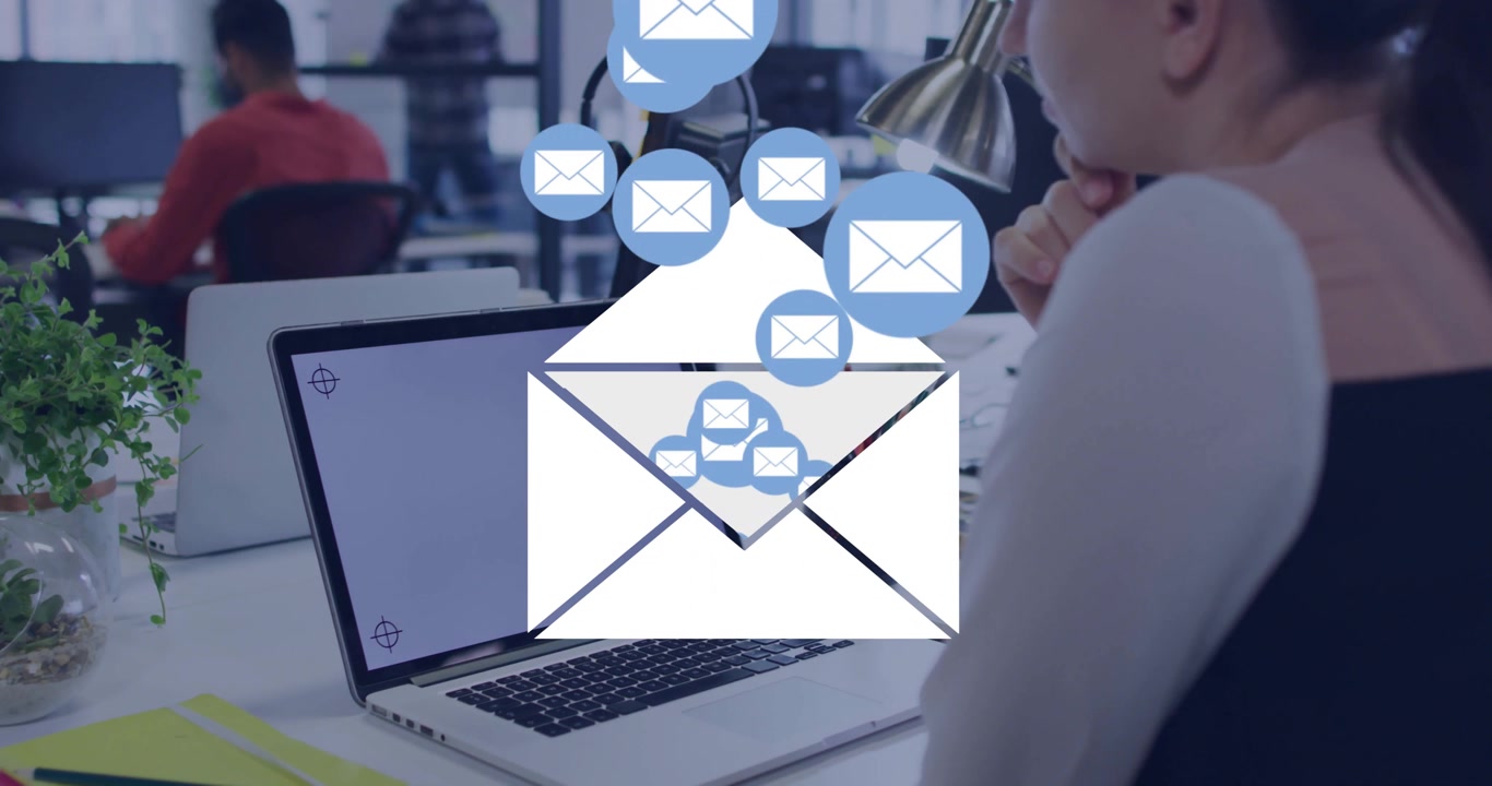 Iconos digitales de notificación de correo electrónico flotando sobre un portátil en una oficina