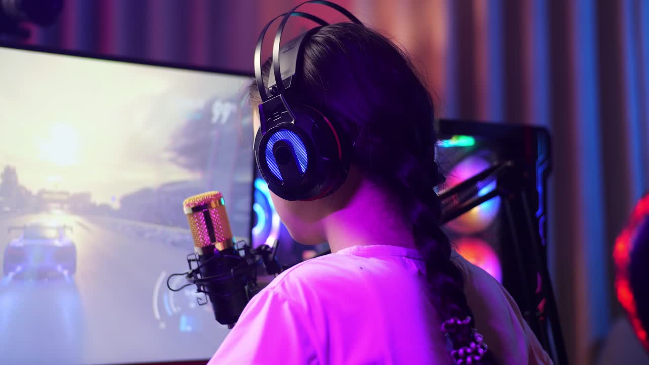 vista de atrás de cerca de la chica asiática streamer gritando gol celebrando el juego de carreras de coches ganador a través de la red en la computadora personal. videojuego de transmisión en vivo, escritorio iluminado por luz de tira de led rgb