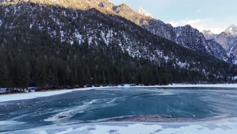 Frozen lake in Italian Dolomites surrounded by outstanding mountains (drone footage)