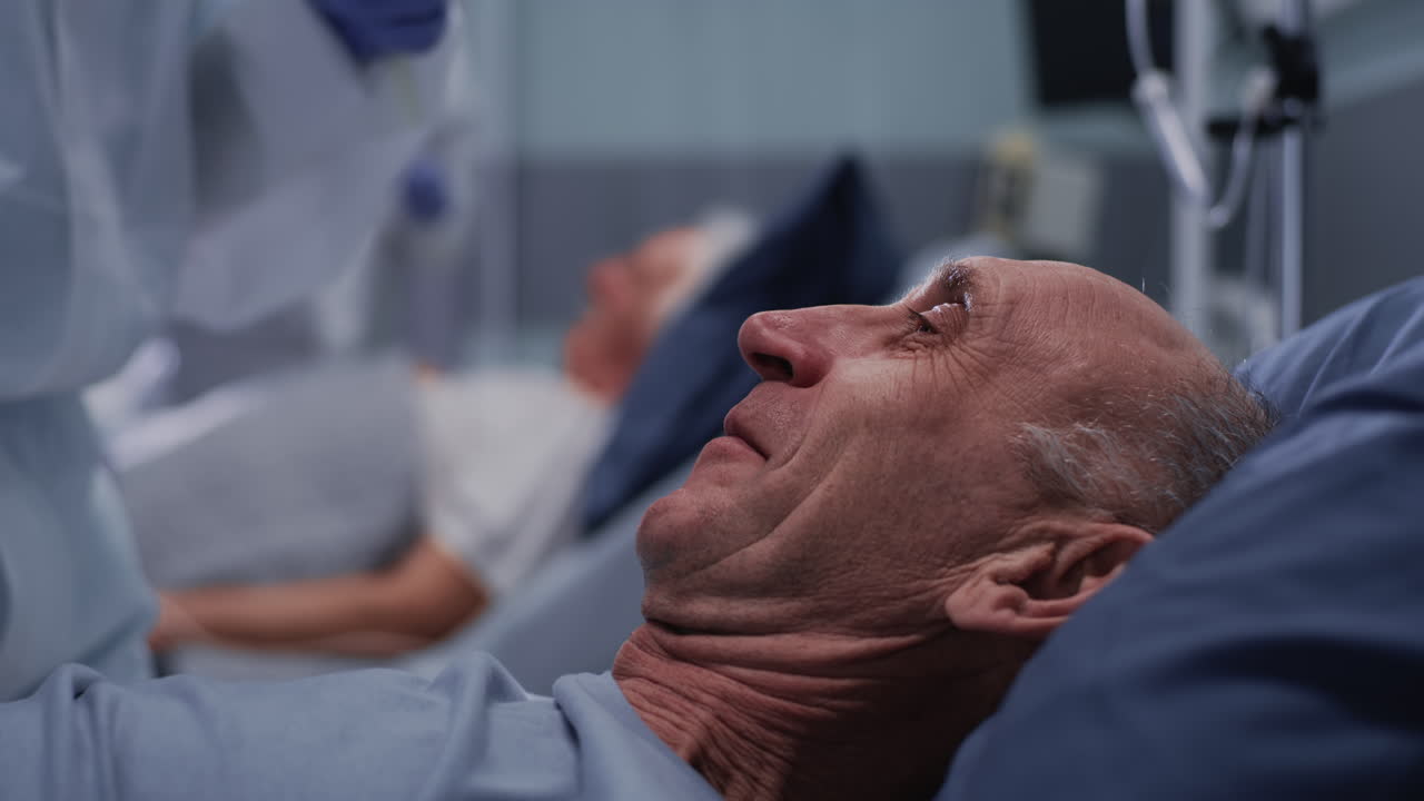 Healthcare worker performs nasal swab COVID-19 test on elderly patient in hospital