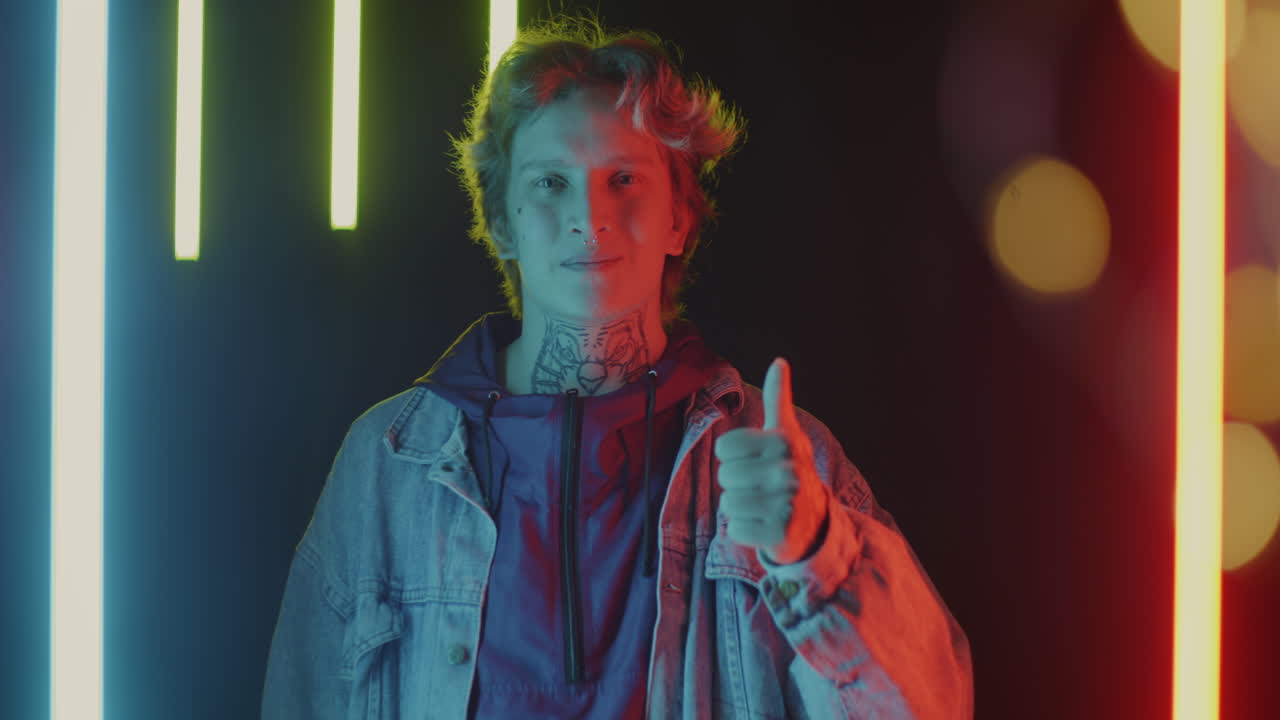 Stylish Young Adult with Tattoos and Piercings in Neon Light