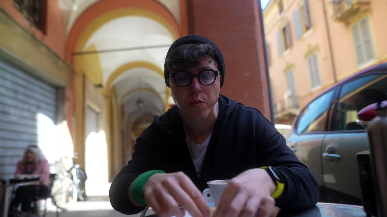 Person eating bread and coffee in a European street cafe