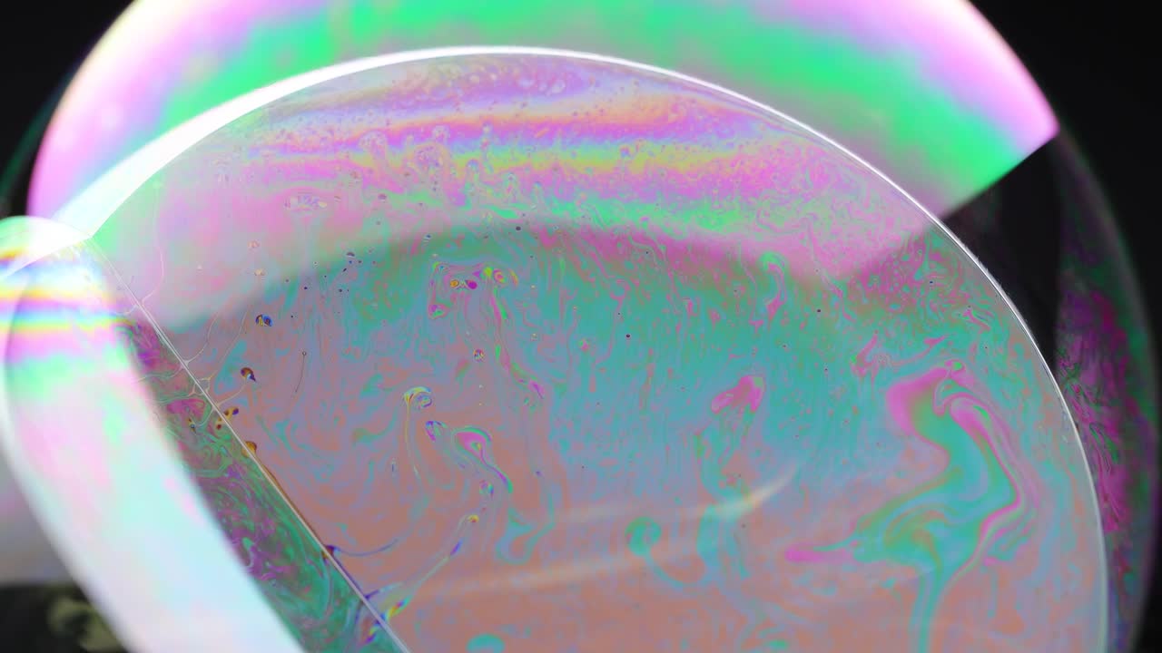 Vibrant soap bubble displays swirling colors and reflections in close-up view, captured with dynamic lighting and smooth camera movement