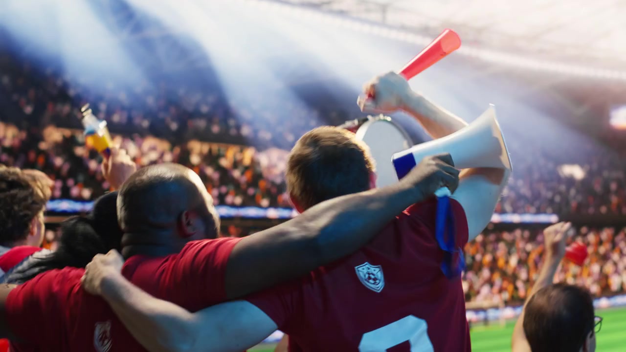 Amigos eufóricos celebran la victoria del partido en las gradas del estadio de fútbol.