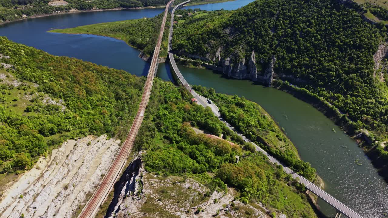 Binari ferroviari e fiumi in un paesaggio verde di giorno.