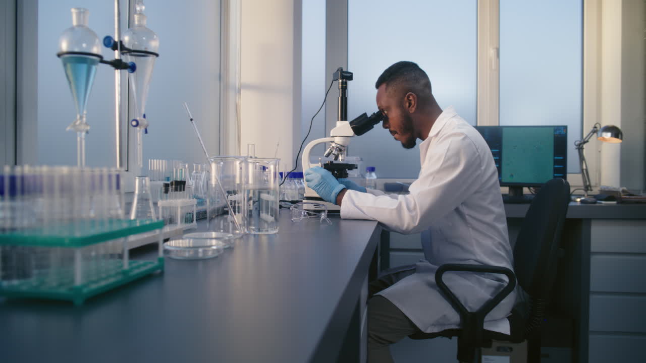 Scientist Working with Microscope in Lab