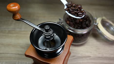 Left-hand-taking-a-spoon-and-then-taking-beans-from-the-jar-into-the-grinder