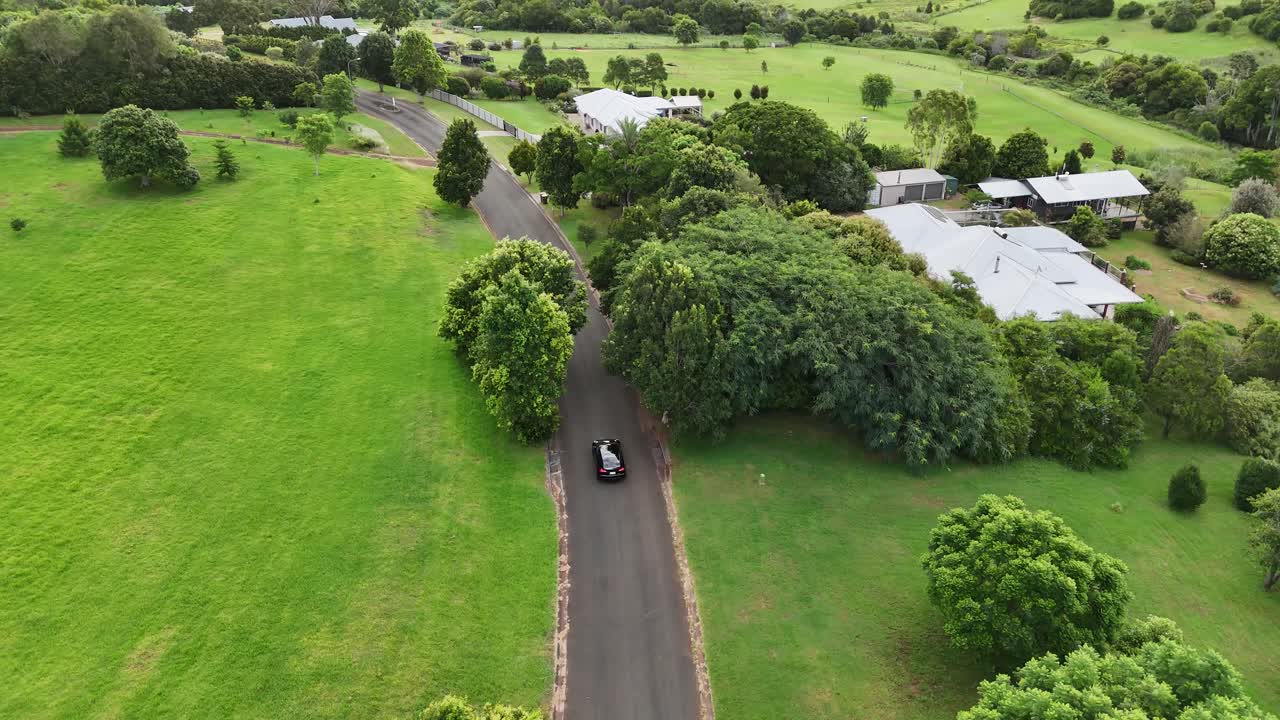 집 과 나무 가 있는 시골 도로 의 공중 사진