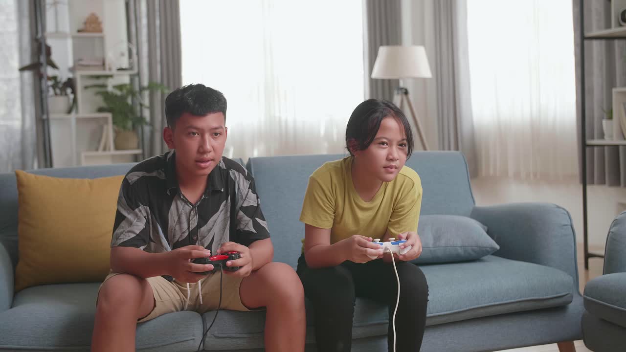 Siblings Playing Video Games at Home