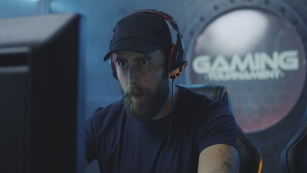 Happy Young Man Finishing Playing Video Game and Celebrating Winning Tilt up View of Happy Caucasian Young Man Finishing Playing Video Game and Celebrating Winning while Sitting in Gaming Chair in front of Computer Monitor