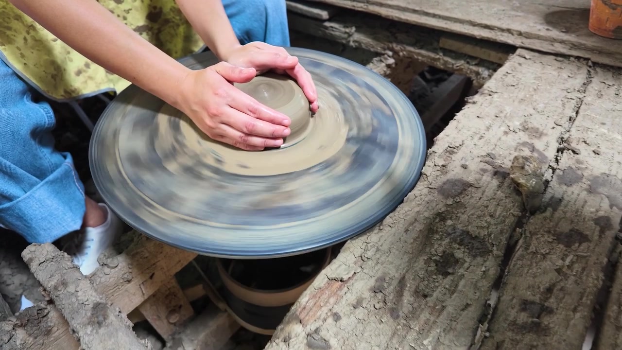 Primo piano di mani che modellano l'argilla su una ruota rotante a Koh Kret, Thailandia
