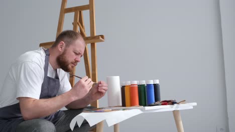 conceived focused young artist is preparing to create a modern masterpiece - conceived focused young artist is preparing to create a modern masterpiece. the talented artist works in the studio. the artist thinks and looks out the window