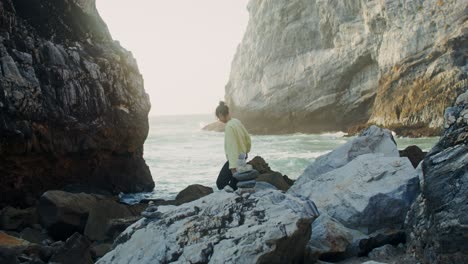 mujer meditando en las rocas junto al mar