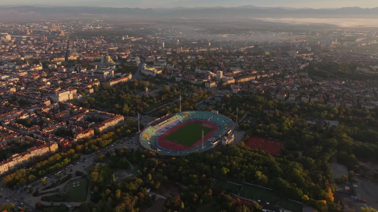 Vista drone dello stadio nazionale incorniciato dalla città e dalle colline all'alba, Bulgaria