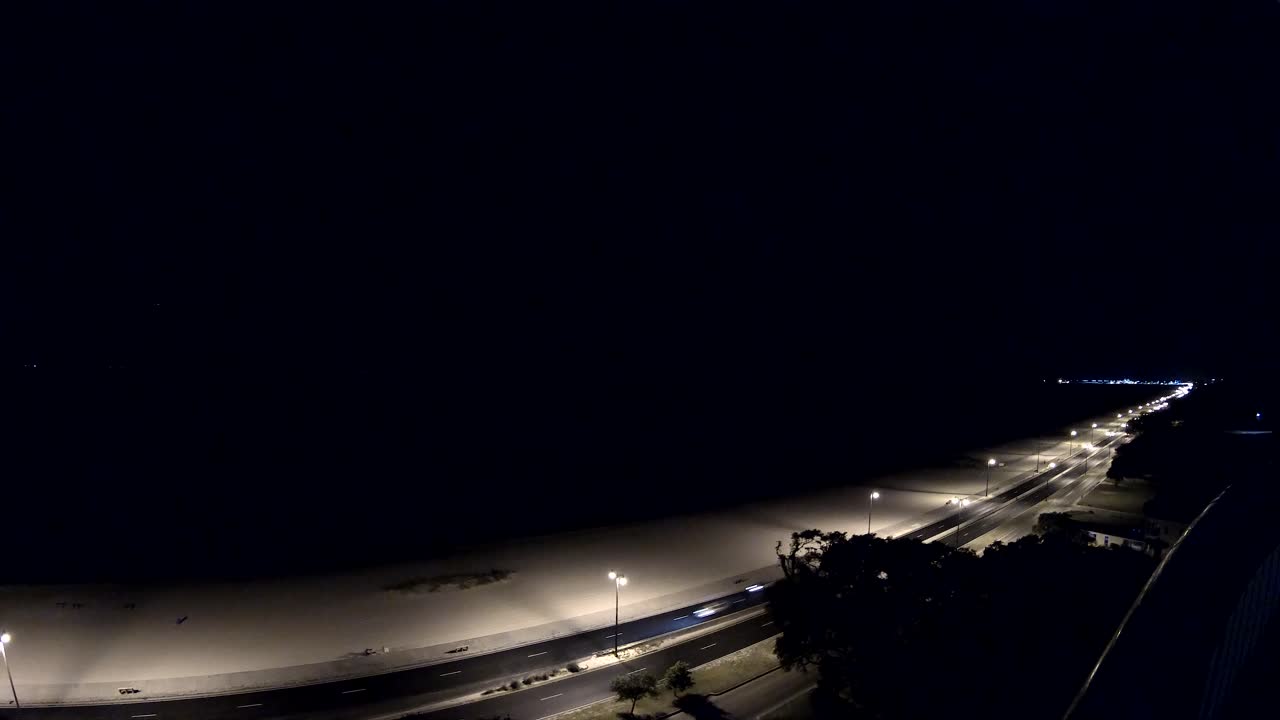 전체 길이를 달리고 멀리 좌회전하는 도로에서 꽤 많은 자동차의 야간 저속 촬영, 가로등 하나가 전체 시간 동안 깜박입니다 - 14층 보기