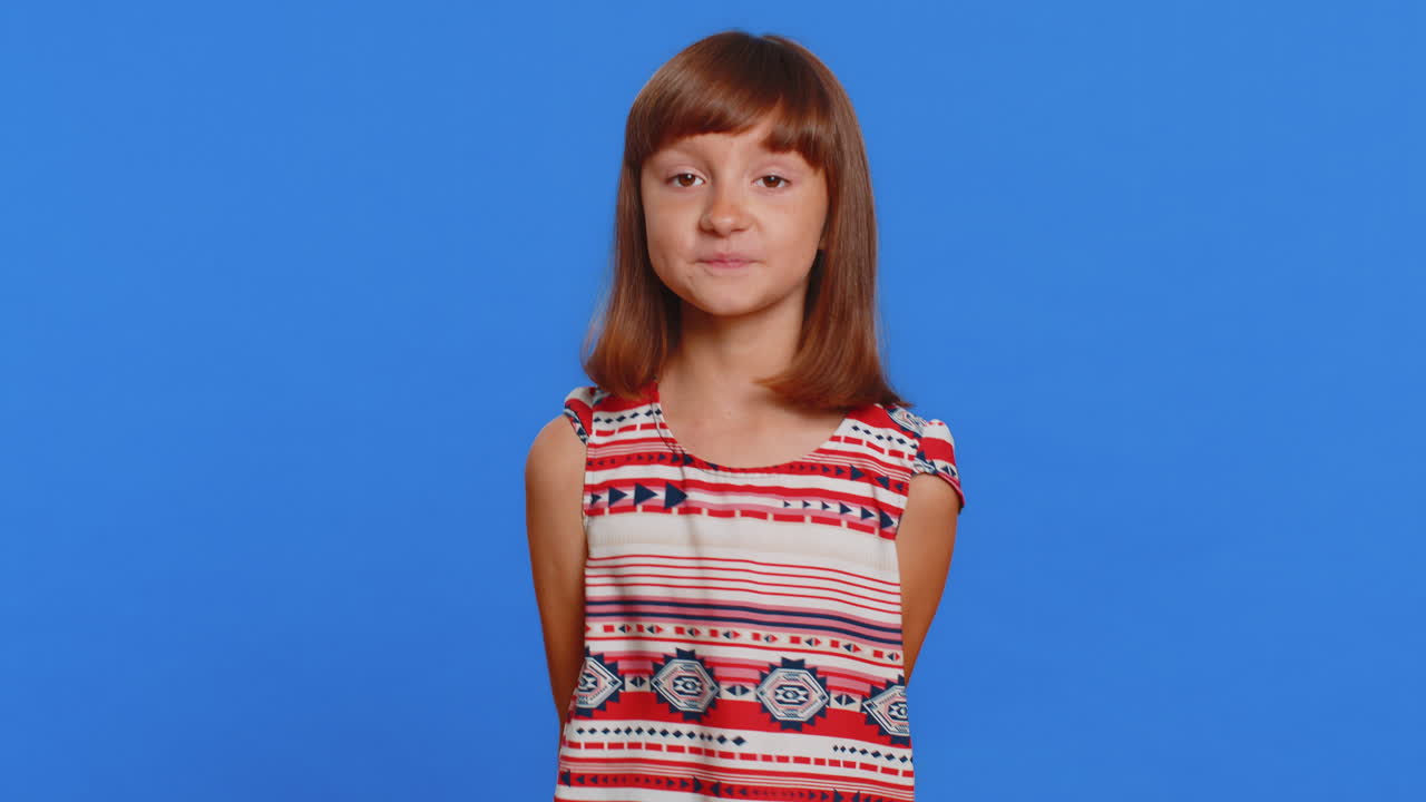 joven con una camisa de patrón rojo y blanco sonríe a la cámara sobre un fondo azul