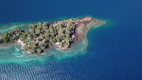 birds eye aerial view of magical island in blue lake water