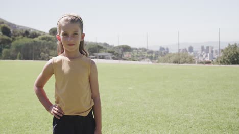 portrait of happy caucasian girl on sunny elementary school playing field, copy space, slow motion